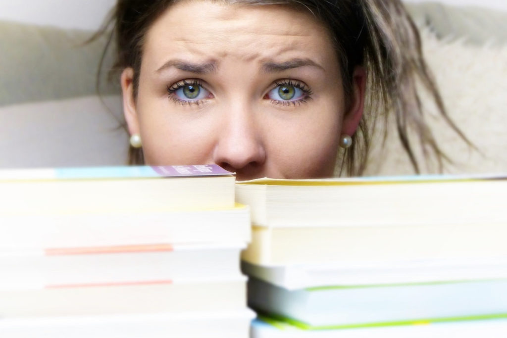 woman in front of books, worried and stressed